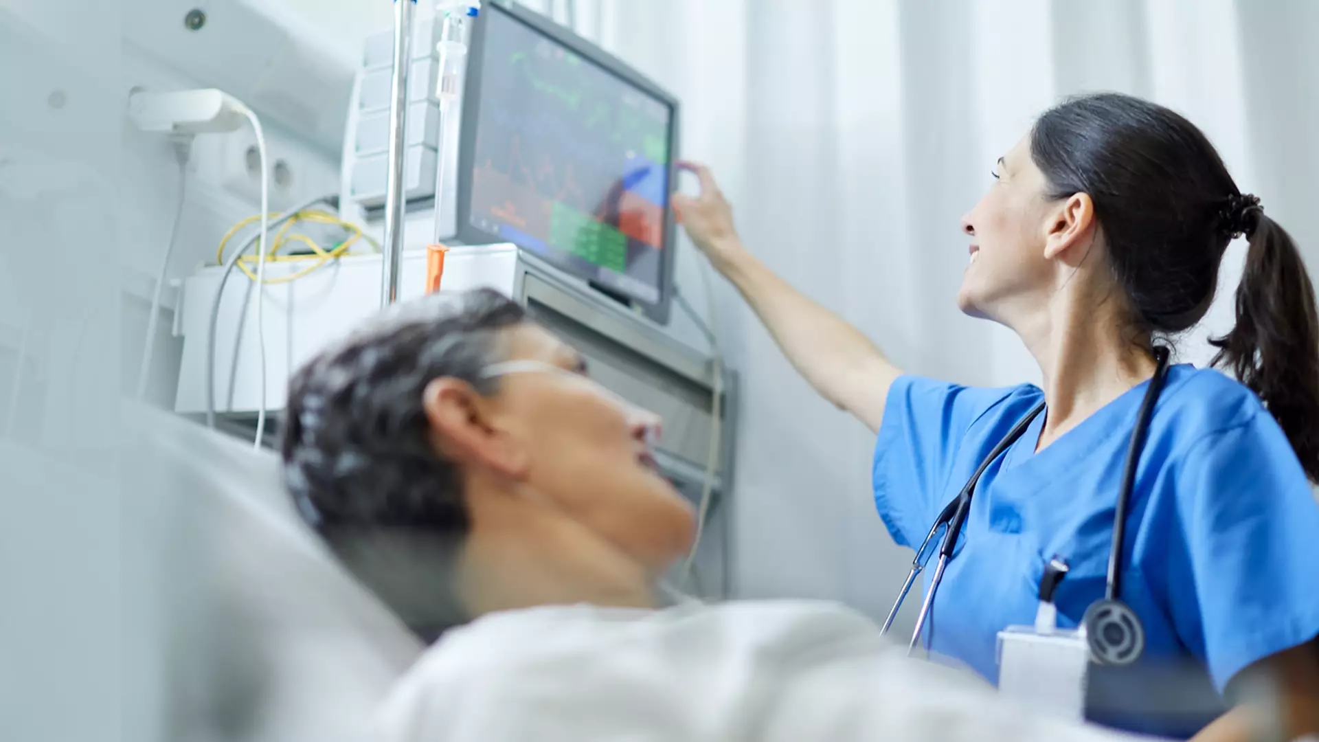 Mother holds newborn baby in hospital bed